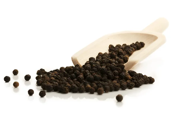 stock image Black peppercorns with a wooden shovel diagonal