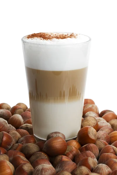 Latte macchiato between a lot of hazelnuts — Stock Photo, Image