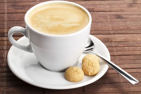Café en una taza blanca con amarettini y cuchara —  Fotos de Stock