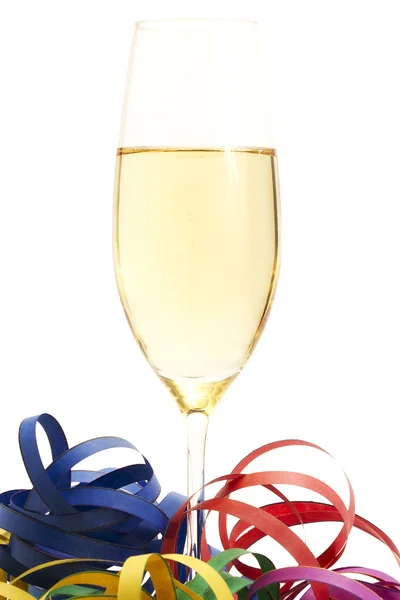 Glass of champagne between streamer — Stock Photo, Image