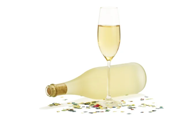 Sklenka šampaňského před prosecco láhev s konfety — Stock fotografie