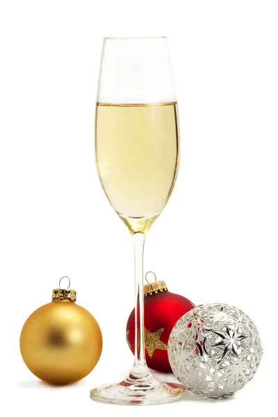 Glass of champagne with golden, red and metal christmas balls — Stock Photo, Image