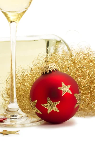 Red christmas ball near glass with champagne, angels hair in front of a cha — Stock Photo, Image