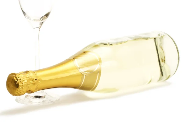 Liggande Champagneflaska med en tom champagne glas — Stockfoto