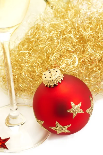 Palla di Natale rossa da cima con capelli di angeli e un bicchiere di champagne — Foto Stock