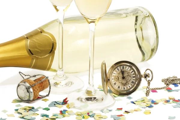 Due bicchieri con champagne, vecchio orologio da tasca, sughero e coriandoli davanti — Foto Stock