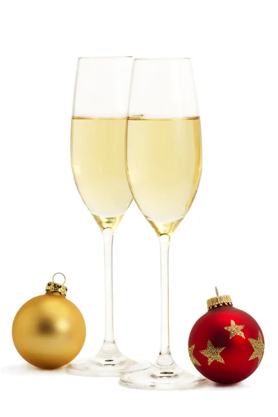 Dois copos com champanhe e uma bola de Natal vermelha e dourada — Fotografia de Stock