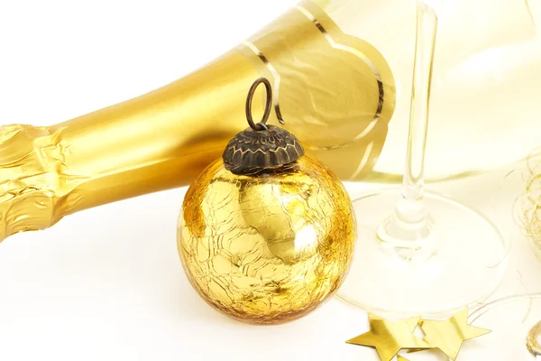 Una bola de Navidad vintage de oro con fondo de una copa de champán y un cham —  Fotos de Stock