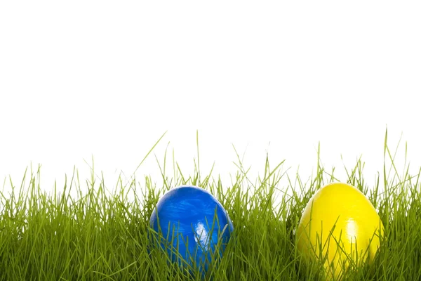 Blue and yellow easter egg in grass — Stock Photo, Image