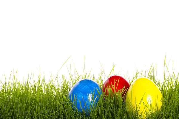 Huevo de Pascua rojo azul y amarillo en la hierba — Foto de Stock