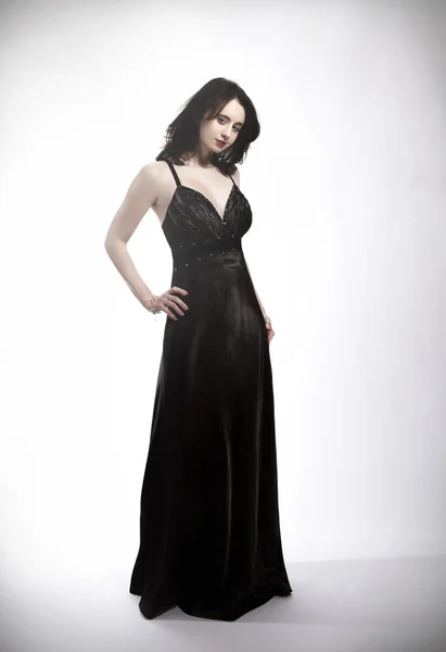 Stehende junge schöne Frau im schwarzen Kleid — Stockfoto