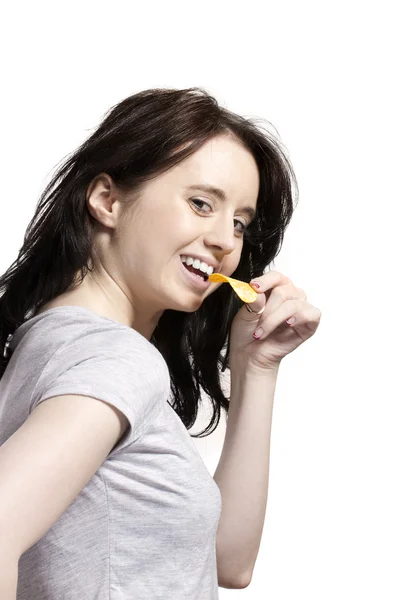 Jovem mulher comer batata frita — Fotografia de Stock