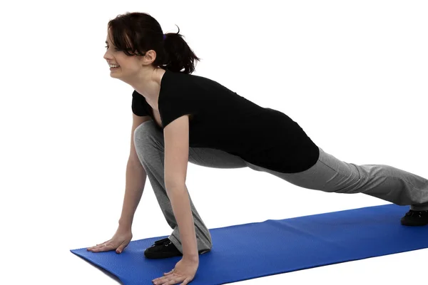 Mujer joven haciendo ejercicio en estera azul —  Fotos de Stock