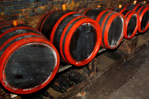 Barris de vinho empilhados na antiga adega da adega — Fotografia de Stock
