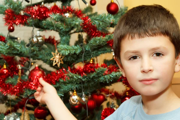 Ung pojke håller juldekorationer — Stockfoto
