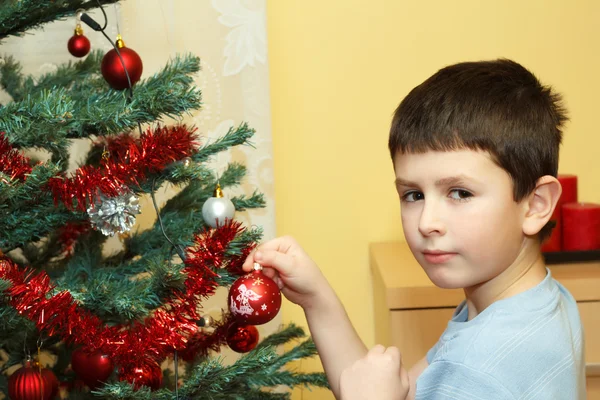 Ung pojke håller juldekorationer — Stockfoto