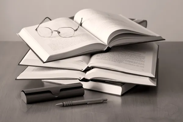 打开的书籍钢笔和眼镜的棕褐色背景 — 图库照片