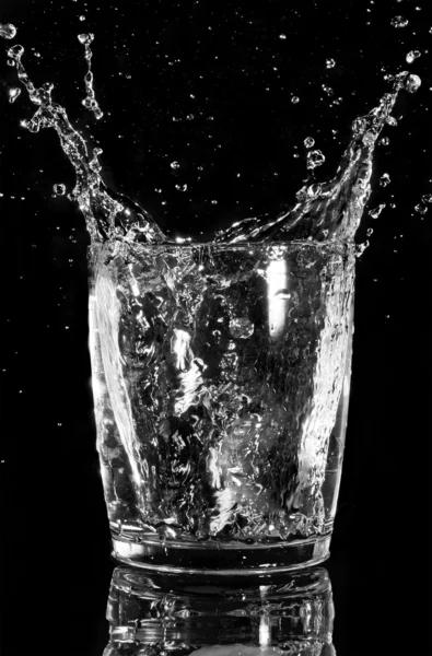 Vattenstänk i glas, isolerade på svart — Stockfoto