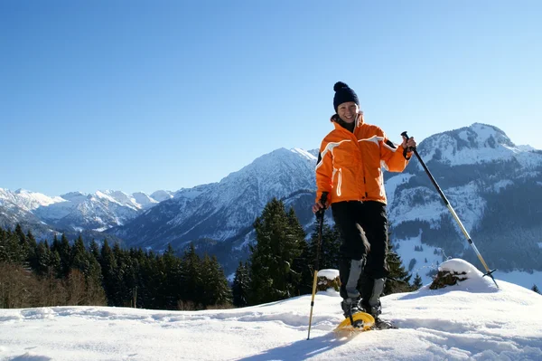 Eine Frau Macht Eine Schneeschuhtour Einer Wunderschönen Berglandschaft lizenzfreie Stockbilder