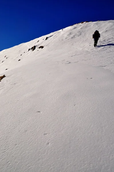 Турист на сніжному схилі пагорба . — стокове фото