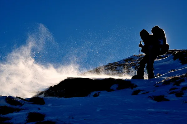 De toerist op een heuvel in sneeuwstorm — Stockfoto