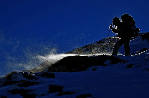El turista en una ladera en tormenta de nieve — Foto de Stock