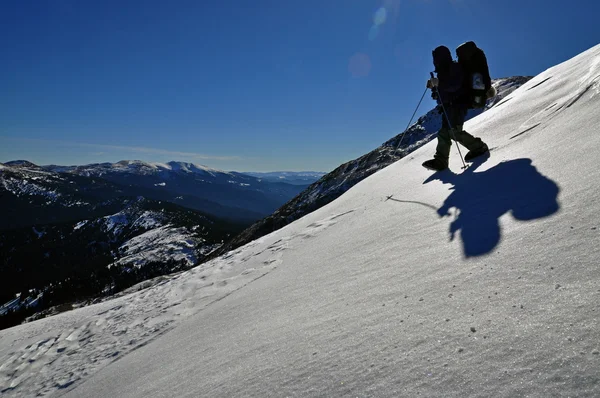Turysta na wzgórzu śnieg. — Zdjęcie stockowe