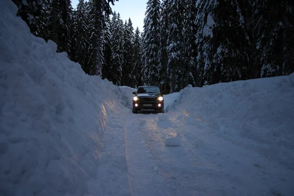 Автомобиль на снежной дороге — стоковое фото