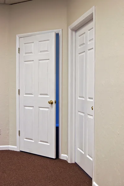 Två vita dörrar en öppen — Stockfoto