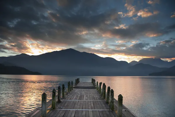 Sunrise over mountain and Looking over a pier — Stock Photo, Image