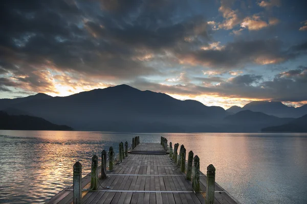 Lever de soleil sur la montagne et regarder sur une jetée — Photo