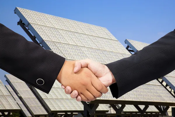 Бизнесмен пожимает руку перед солнечной электростанцией — стоковое фото