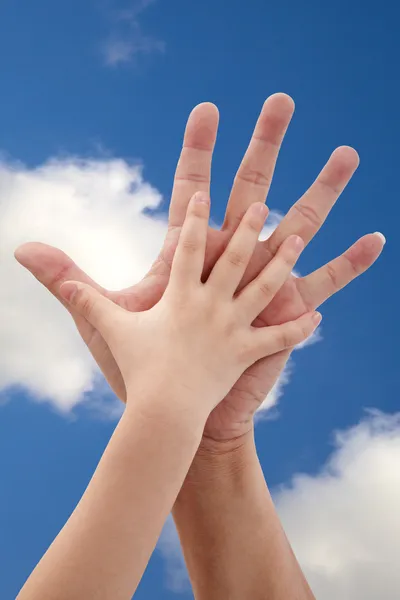 Father and daughter's hand under blue sky — Stock Photo, Image