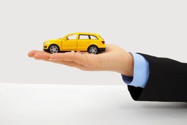 Businessman's hand holding a car clipart