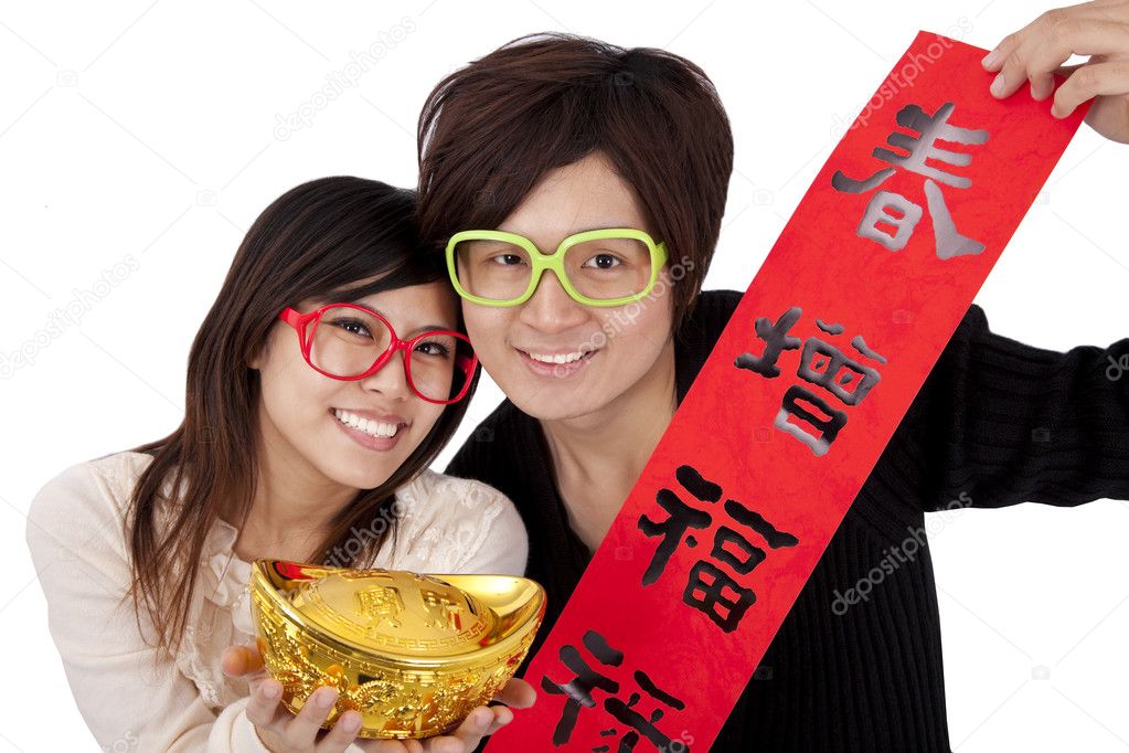 Happy chinese new year. Young couple holding gold ingot and red spring couplets