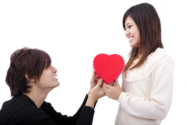 Asiatischer junger Mann übergibt Liebesgeschenk an junge Frau — Stockfoto