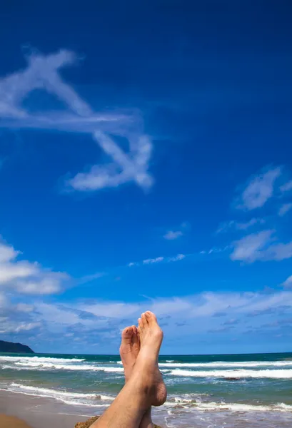 Sdraiato sulla spiaggia con nuvola simbolo dollaro — Foto Stock