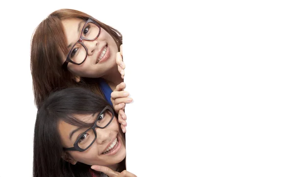 Dos chicas sonrientes y hermosas detrás de la pizarra blanca —  Fotos de Stock