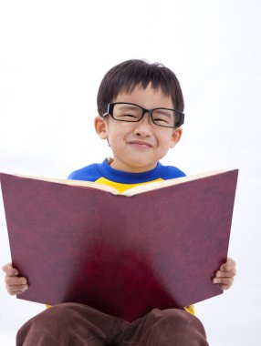 Happy young asian boy with book.Isolated with white background. clipart