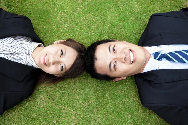 Couple.happy homme d'affaires et femme Allongé sur l'herbe — Photo