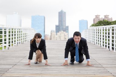 Business man and woman getting ready for race in business clipart