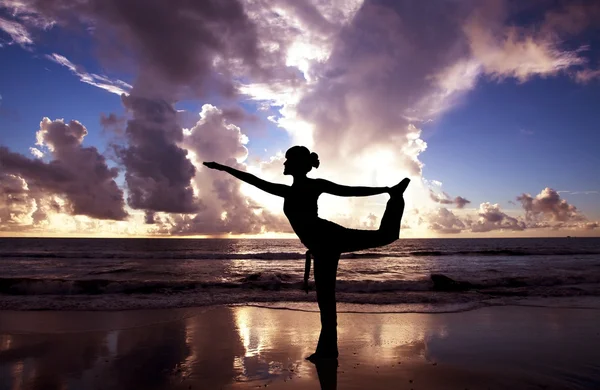 Joga kobieta na pięknej plaży o wschodzie słońca — Zdjęcie stockowe