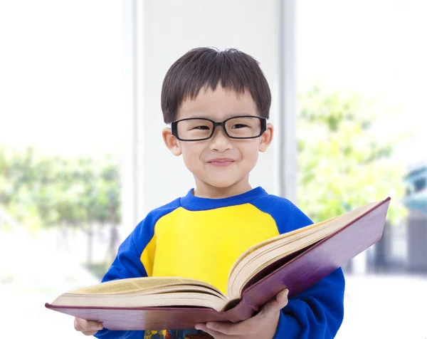 Asiático niño sonriendo y sosteniendo libro — Foto de Stock