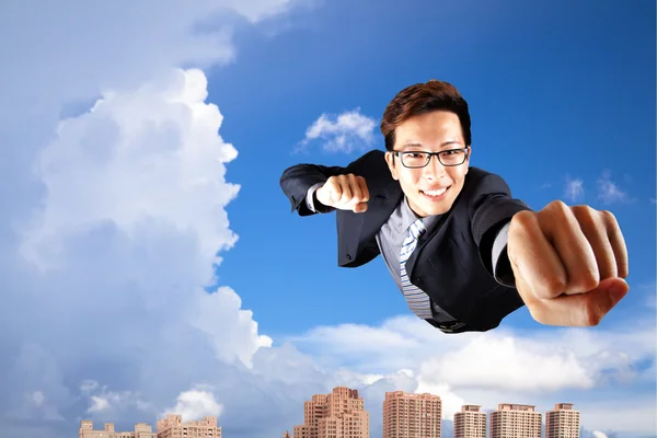 Affärsman flyger i himlen över staden — Stockfoto