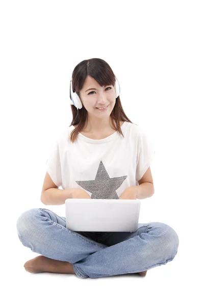 Jonge vrouw die op laptop werkt en muziek luisteren — Stockfoto