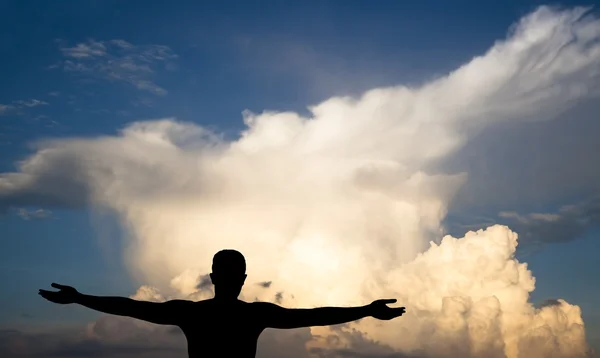 Jonge man op wolken, zwart silhouet — Stockfoto