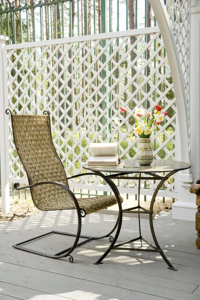 Houpací židle a malý stolek na verandě Royalty Free Stock Obrázky