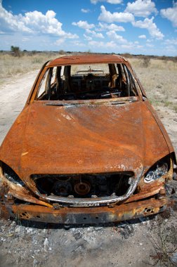 Abandoned Car in Field Under Blue Sky clipart