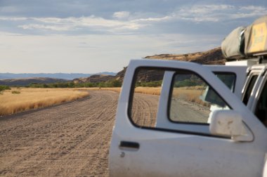 Car with open doors and desert view clipart