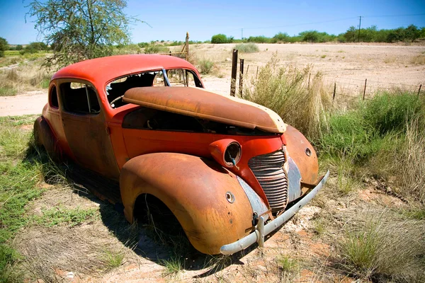 Carro abandonado no campo sob céu azul — Fotografia de Stock